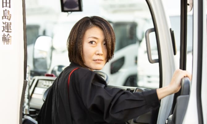 トラックを運転する女性ドライバーの横顔